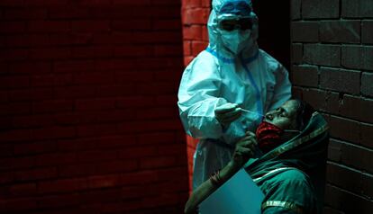 Un sanitario realiza una prueba PCR para detectar la covid-19 en una ciudadana en Nueva Delhi (India).