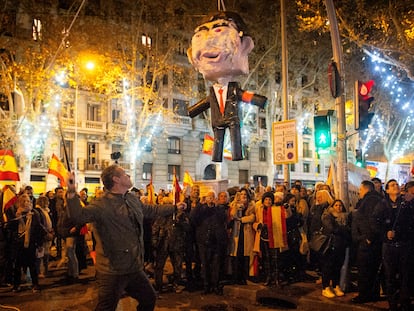 Un hombre se disponía en Nochevieja a golpear una piñata que representa a Pedro Sánchez, cerca de la sede del PSOE en Madrid.