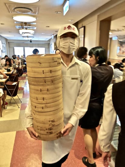 UN CAMARERO CON CESTOS REPLETOS DE XIAO-LONG-BAO / CAPEL