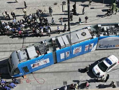 Los operarios del tranvía de Sevilla trabajan para devolverlo a la vía tras descarrilar un vagón.