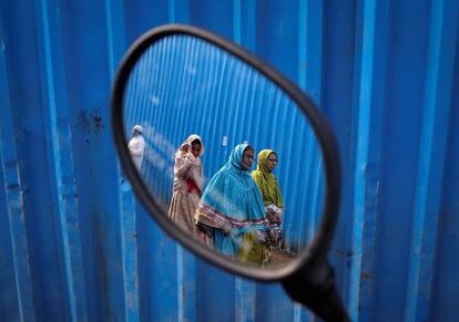 Musulmanas Dawoodi Bohra se ven reflejadas en el retrovisor de una motocicleta, en Bombai (India).