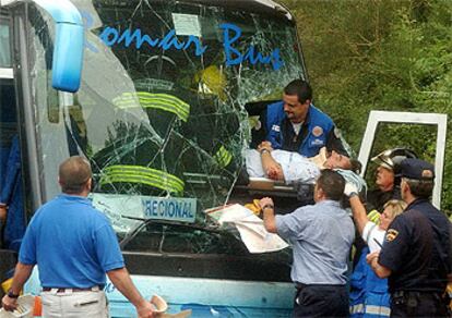 Un equipo de rescate traslada a uno de los heridos, que quedó atrapado en el autobús tras el accidente.