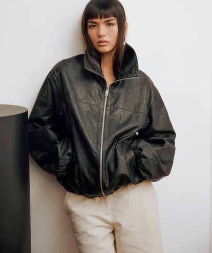 Clara Kong con chaqueta de piel tipo bomber, bermudas de lino y pendiente, todo de MANGO SELECTION.
