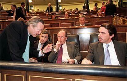 Piqué conversa con Aznar en presencia de Acebes y Rato, ayer en el Congreso de los Diputados.
