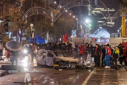 Aficionados de Marruecos, junto a un coche quemado en Bruselas.