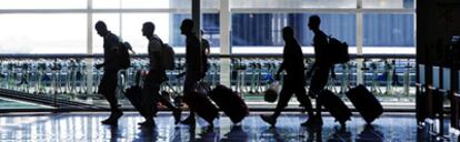 Un grupo de pasajeros arrastra  sus equipajes  por la nueva terminal T1 del aeropuerto de Barcelona.