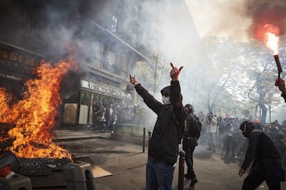 Un miembro de los 'black block' hace un gesto a la policía desde una barricada incendidada, en París.  