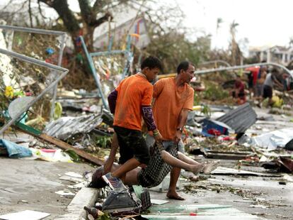 Dos hombres transportan un cadáver de una víctima del tifón Haiyan en la ciudad de Tacloban, provincia de Leyte (Filipinas), 15 de noviembre de 2013.