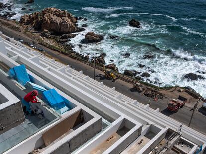 Una trabajadora de la construcción limpia los ventanales de una nueva edificación al costado del borde costero de Valparaíso, el 5 de diciembre de 2022.