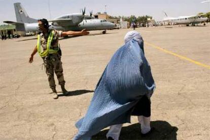 Un soldado español señala el camino a una pasajera en el aeropuerto de Herat.