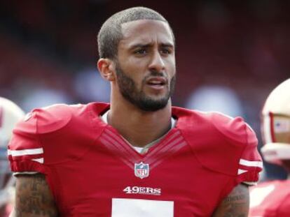 El quarterback de los 49ers, Colin Kaepernick, se niega a ponerse en pie durante el himno nacional antes de los partidos