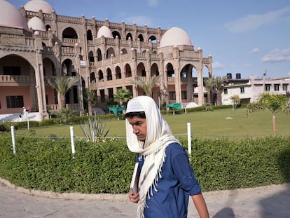 Un alumno pasa camino de clase delante del edificio principal de la Madrasa Haqqanía en Akora Khattak (Pakistán), una famosa escuela coránica con 4.000 alumnos por la que han pasado importantes líderes talibanes, algunos de ellos en el actual gobierno de Kabul.