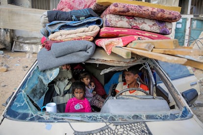 Palestinos desplazados se sientan en un automóvil dañado mientras huyen de la parte oriental de Khan Younis tras una orden de evacuación israelí el 7 de octubre de 2024.