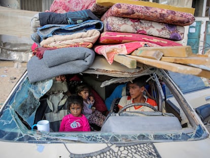 Palestinos desplazados se sientan en un automóvil dañado mientras huyen de la parte oriental de Khan Younis tras una orden de evacuación israelí el 7 de octubre de 2024.