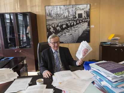 Jean-Claude Juncker holds up a copy of EL PAÍS inside his Brussels office.