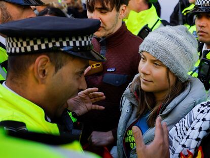 A police officer speaks to Swedish climate campaigner Greta Thunberg during an Oily Money Out and Fossil Free London protest in London, October 17, 2023.