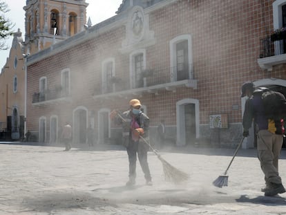 Empleados de limpia barren la ceniza volcánica de una plaza en la ciudad de Atlixco, en el Estado de Puebla.