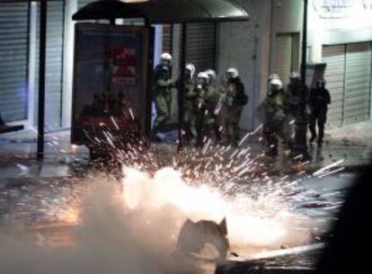 Policía antidisturbios recibe una bomba molotov ayer en Atenas, Grecia. EFE/Archivo