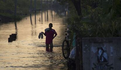 Un hombre camina durante las inundaciones de Bangkok.