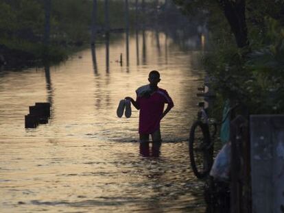 Un hombre camina durante las inundaciones de Bangkok.