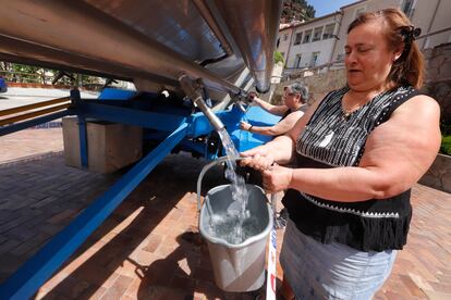 Dos mujeres recogen agua de una cuba en el centro de Vacarisses. © Foto: Cristóbal Castro.