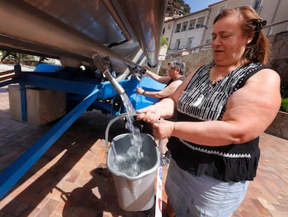 Dos mujeres recogen agua de una cuba en el centro de Vacarisses. © Foto: Cristóbal Castro.