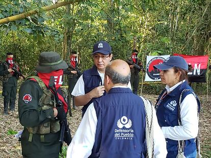 Funcionarios de la  Defensoría del Pueblo hablan con guerrilleros del ELN, durante la liberación de varios soldados y un policía en zona rural de Arauca, el 17 de agosto de 2022.