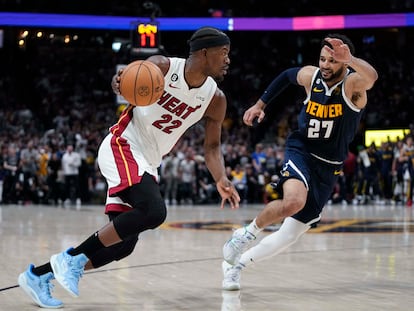 Miami Heat forward Jimmy Butler, left, moves the ball while defended by Denver Nuggets guard Jamal Murray, right, during the first half of Game 2 of basketball's NBA Finals, on June 4, 2023, in Denver.