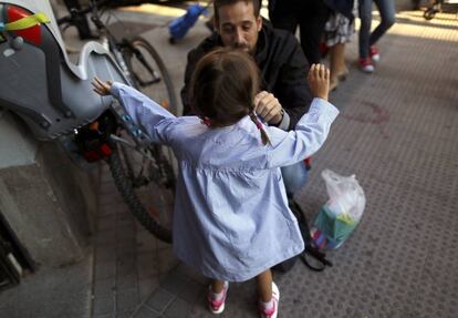 Un padre con su hija a la entrada del colegio.