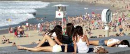 Numerosas personas disfrutan de una jornada de playa en San Sebastián.