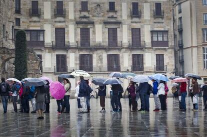 Turistas bajo la lluvia en Barcelona.