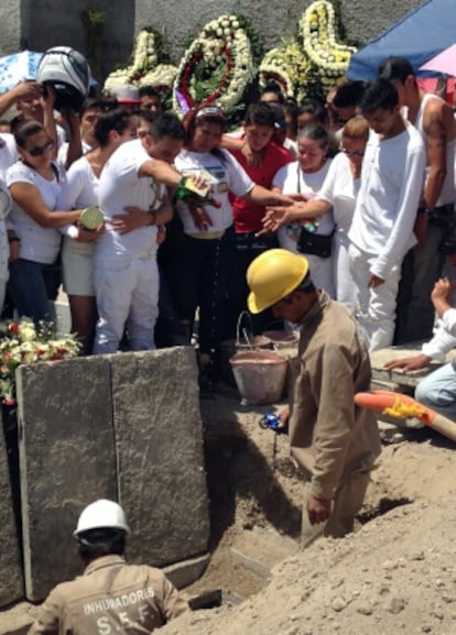Juan Carlos Ortiz vacía una botella de whisky en la tumba de su hermano.
