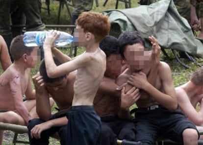 Varios niños se abrazan momentos después de su liberación, mientras uno de ellos bebe agua.