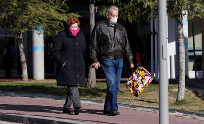 Una pareja con mascarillas, en el exterior del hospital de Torrejón de Ardoz.