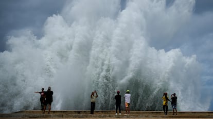 Personas toman fotos del choque de las olas contra el malecón de La Habana ante el paso del huracán Milton, en octubre de 2024.