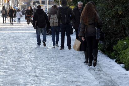 Estudiantes y paseantes caminan con dificultad por las blancas aceras de la avenida Diagonal el día después de la gran nevada.