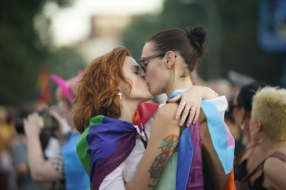 Dos participantes en la marcha del Orgullo en Madrid se funden en un beso.