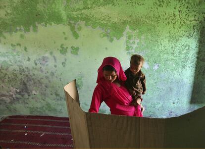 Elecciones generales en India. Una mujer con su hijo en brazos en un centro de votación a las afueras de Jammu.