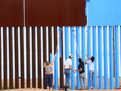 Voluntarios de Erasing the Border pintan la barrera entre EE&nbsp;UU y M&eacute;xico para hacerla invisible.