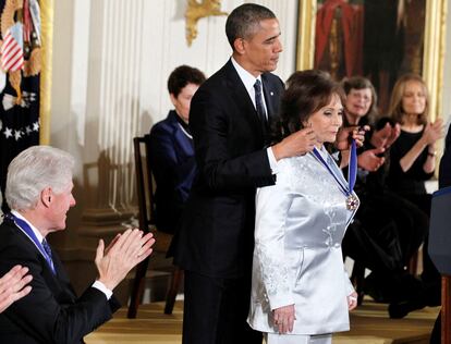 Barack Obama entrega la Medalla Presidencial de la Libertad a Loretta Lynn en la Casa Blanca, el 20 de noviembre de 2013. Sentando, aplaudiendo, Bill Clinton. 