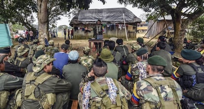 TO GO WITH AFP STORY by Hector Velasco
Tomas (C), a member of the Revolutionary Armed Forces of Colombia (FARC), talks about the peace process between the Colombian government and their force, to guerrillas during a "class" at a camp in the Colombian mountains on February 18, 2016. They still wear green combat fatigues and carry rifles and machetes, but now FARC rebel troops are sitting down in the jungle to receive "classes" on how life will be when they lay down their arms, if their leaders sign a peace deal in March as hoped.  AFP PHOTO / LUIS ACOSTA