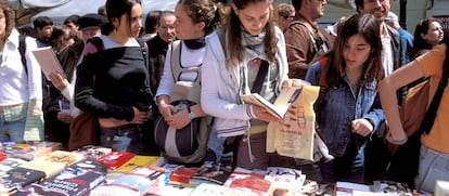 Varios visitantes en uno de los puestos de las librerías por Sant Jordi, en 2017 en Barcelona.