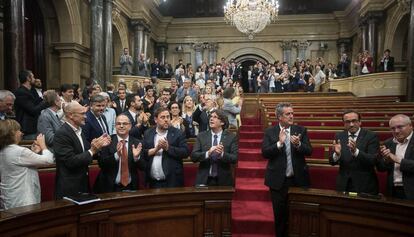 Puigdemont i altres membres del Govern aplaudeixen després de l'aprovació de la llei.