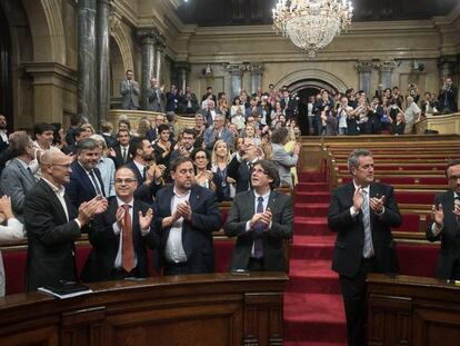 Puigdemont i altres membres del Govern aplaudeixen després de l'aprovació de la llei.