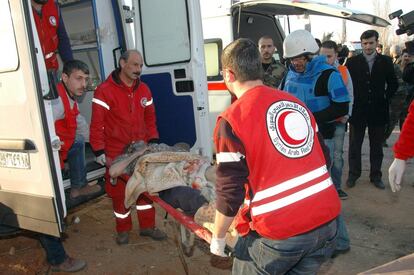 Trabajadores de la Media Luna Roja Siria ofrecen ayuda a los civiles de un centro de refugiados de Homs.