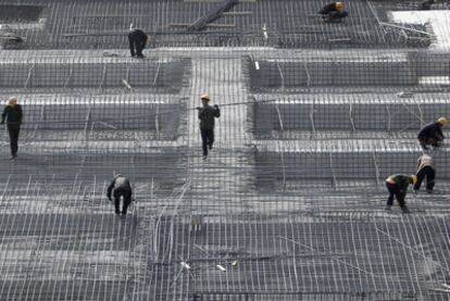 Obreros chinos de la construcción trabajan en la preparación del encofrado de un edificio en la capital del país,  Pekín.