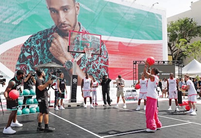 Lewis Hamilton durante el IWC Chrono Challenge de baloncesto organizado por la firma IWC Schaffhausen en Miami. Bajo la canasta, el skater olímpico Jagger Eaton y la leyenda de la NFL Antrel Rolle. A la derecha, pasándole balones, el actor James Marsden.