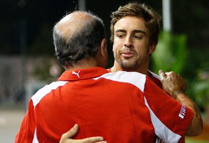 Emilio Botín y Fernando Alonso se saludan tras un paseo en bicicleta por el circuito de Singapur