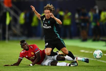 Luka Modric (derecha) cae ante la entrada de Paul Pogba.