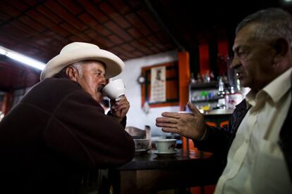 Dos hombres charlan mientras beben café.